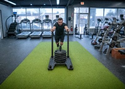 man pushing sled with heavy weights personal training gym morton grove steel fitness club